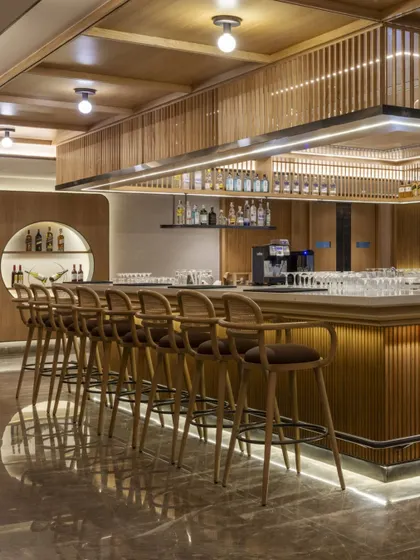 The well-appointed bar at Radisson Resort, featuring warm wood tones and elegant lighting. The design includes high-back bar stools and a clean, functional layout, making it an inviting space for guests to gather.