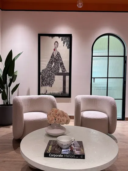 The client lounge in our studio, featuring plush boucle armchairs, a micro-concrete coffee table, and large-scale art to create a welcoming atmosphere.