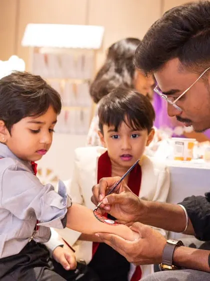 A tattoo artist engaging with young guests at a birthday party. I not only capture the main events but also the fun activities and interactions happening on the sidelines.