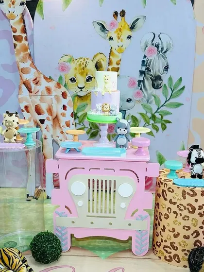 A detailed shot of the pastel safari theme, focusing on the pink jeep dessert cart and adorable animal figurines.