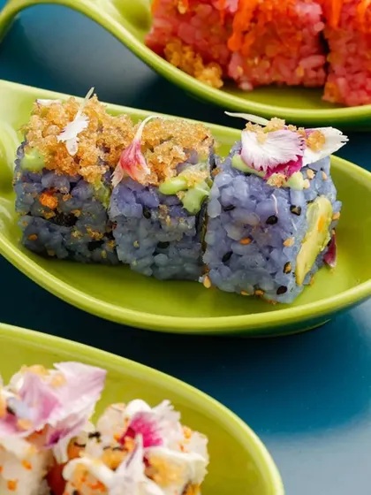 A colourful trio of our signature sushi rolls, each served in an individual, leaf-shaped green dish. This presentation highlights the variety and artistry of our Pan-Asian offerings.