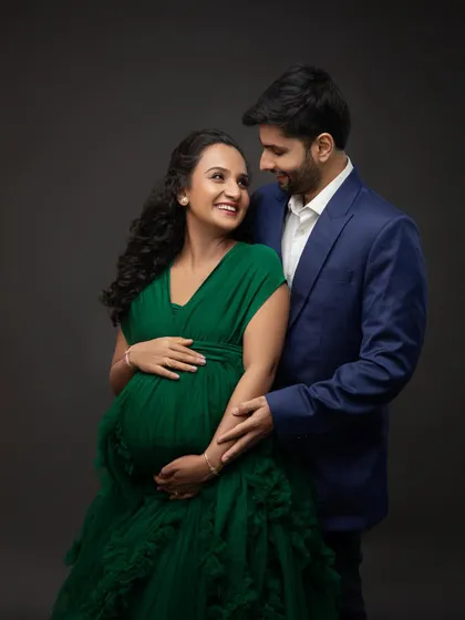 The look they share is full of love and excitement. His classic blue suit perfectly complements her stunning green gown.