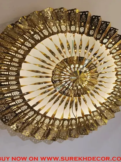 This exclusive imported metal wall art is a true statement piece. The intricate, spiraling design in antique gold features detailed cutouts and is fitted with LED lights, creating a mesmerizing and luxurious focal point.