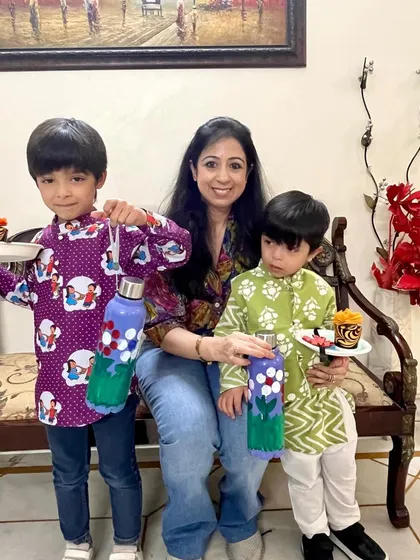 The final masterpieces. Two brothers hold up their beautifully painted bottles and decorated puja thalis from our Rakshabandhan workshop, ready to celebrate the festival with their handmade creations.