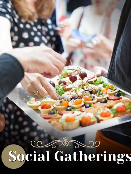 A server offering a tray of assorted canapés to guests at a social gathering. This highlights our attentive pass-around service for cocktail hours and networking events.