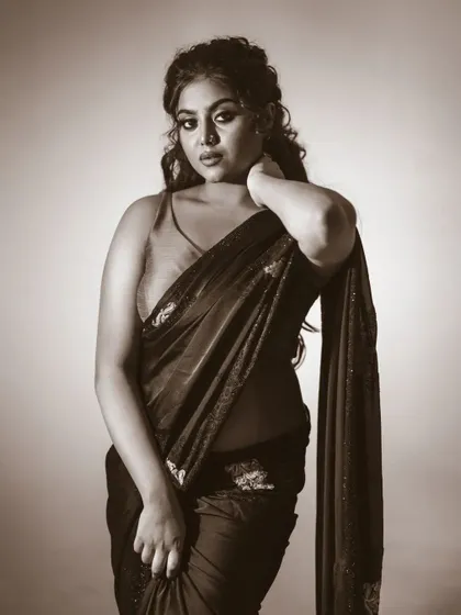 A classic portrait in a saree, rendered in a beautiful sepia-toned black and white. This gives the image a vintage, timeless quality.