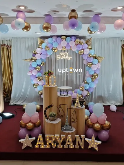 A stylish birthday setup with a circular balloon wreath in pastel colors.