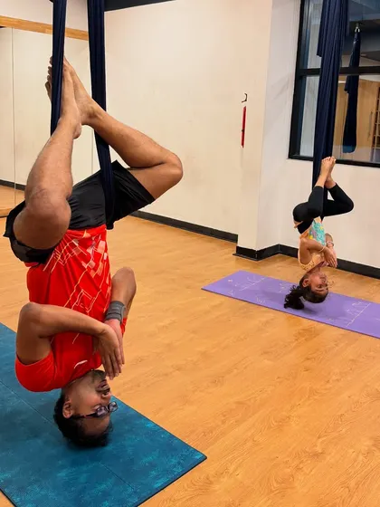 An inverted prayer pose in the hammock. This anti-gravity position helps improve circulation, calm the nervous system, and offers a new perspective.