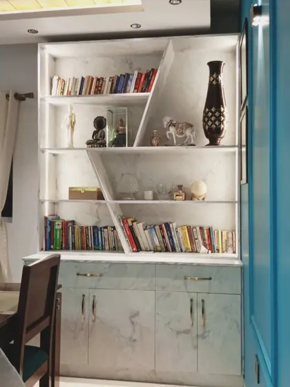 A unique bookshelf and storage unit with a marble finish and integrated lighting. This custom piece is both a functional library and a beautiful decorative element in the living space.