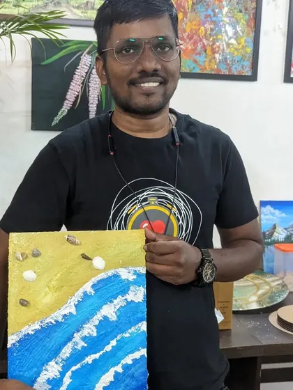 A participant with his beach-themed texture painting, complete with real shells embedded in the textured sand.