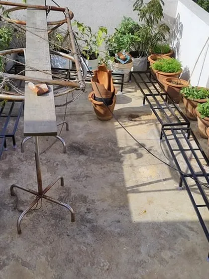 An empty terrace with our stands placed, ready for the plants. This shows the basic framework we use to build a clean and organized rooftop garden.