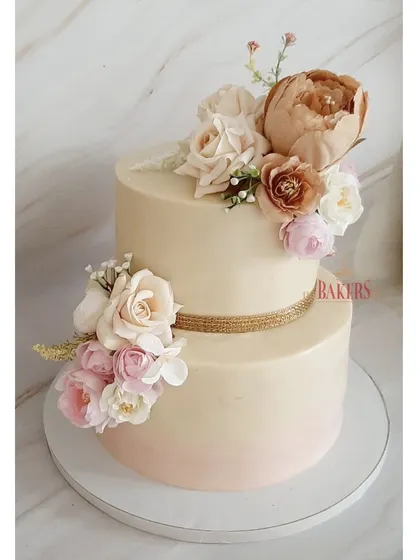 A beautiful no-fondant cake in a nude color palette for an engagement party. The subtle ombre effect and the arrangement of rustic, neutral-toned flowers give it a sophisticated and modern feel.