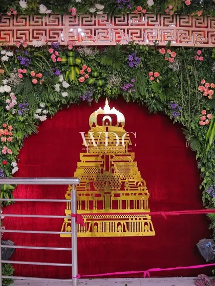 A floral archway at the Jhandewalan Temple for Navratri, with a cutout of a temple against a red velvet backdrop, surrounded by a profusion of flowers.