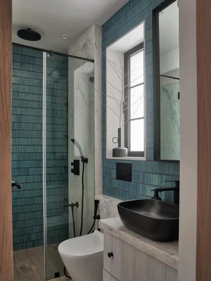 For this powder bathroom, we combined teal mosaic tiles with Carrara marble for the walls and used wooden tiles for the floor. Black Kohler fixtures complete the look, adding an elegant and glamorous touch.