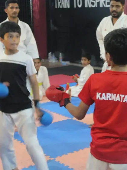 Students practice their sparring during a belt grading test. This demonstrates their ability to apply their techniques in a controlled, dynamic situation.