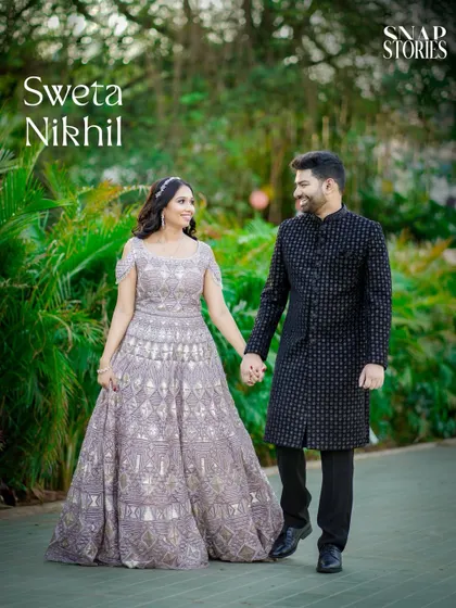 A lovely shot of a couple walking hand-in-hand in a park, dressed in elegant attire. This blends formal style with a natural, relaxed environment.