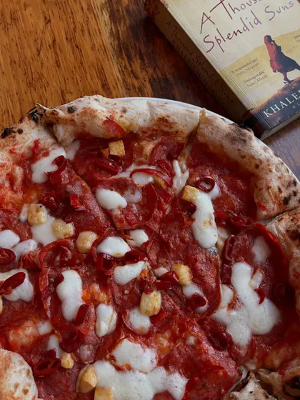 A spicy pepperoni pizza next to a good book. Our idea of a perfect evening.