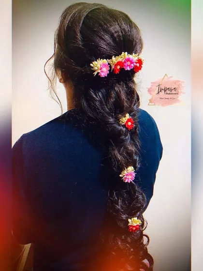 An advanced hairstyle with a floral-decorated messy braid, created during one of my hairstyling classes. This shows the kind of intricate and modern styles I can create.