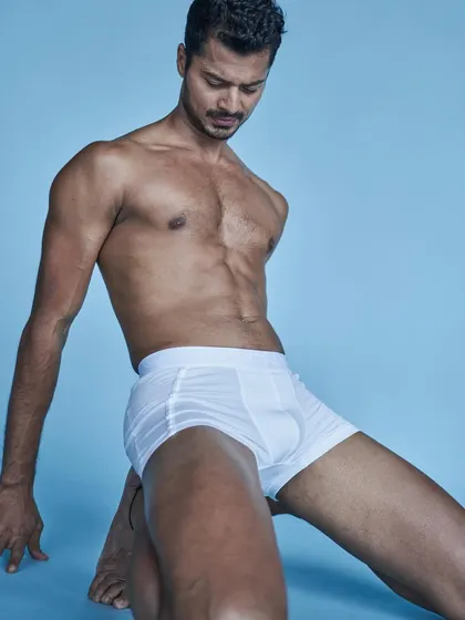An artistic studio shot in white briefs, focusing on the lines and form of the human body.