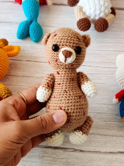 This classic crochet teddy bear is a timeless friend for any child. It's handmade with soft yarn, making it perfect for cuddles.