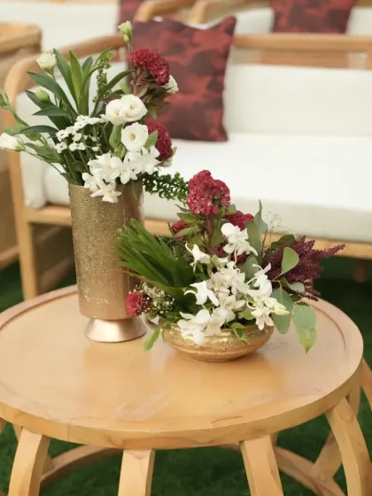 Another elegant centerpiece in a golden vase, designed to complement the sophisticated seating area for guests.