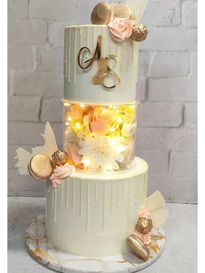 Welcome! I believe every celebration deserves a showstopper. This three-tiered cake, with its glowing LED lights and delicate white chocolate drip, is an example of how we can make your special day truly shine. I love taking a classic design and adding a modern, memorable twist.