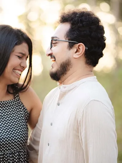 A candid shot of Anjum and Soham sharing a laugh. Their genuine smiles and the soft, natural background make this a warm and inviting portrait.