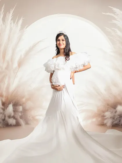 For the mom-to-be who dreams of a fairytale moment. This setup features a regal white gown, a tiara, and a dreamy pampas grass arch, creating an ethereal and angelic portrait. It’s about making you feel like the queen you are during this special time.