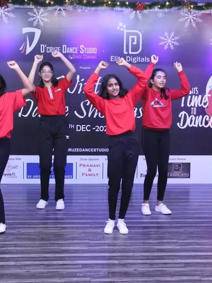 The dancers raise their arms in a joyful moment of their festive performance.
