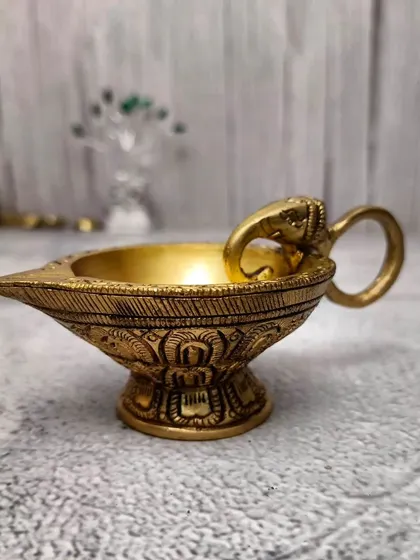This brass diya is designed with an elephant handle, symbolizing strength and good fortune. It has a classic, heavy feel and is perfect for traditional pooja setups.