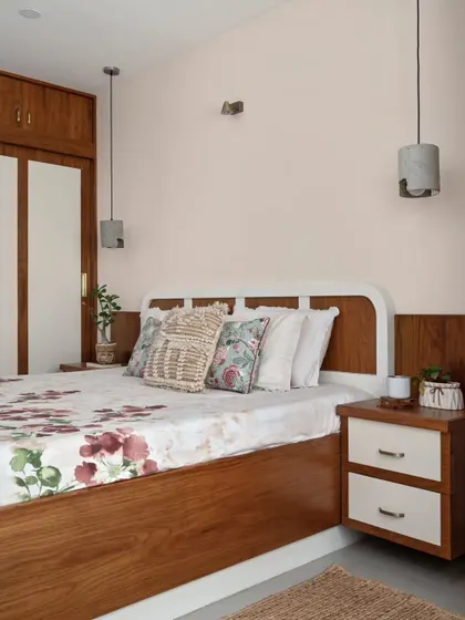 Another angle of the master bedroom, showing the cream-toned wall and the harmony between the bespoke side tables, closets, and floral bed linens.