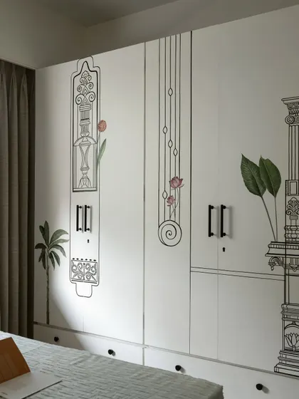 The wardrobe doors in this Kolam Pop bedroom feature delicate, linear illustrations of traditional South Indian architectural elements, turning storage into a storytelling device.