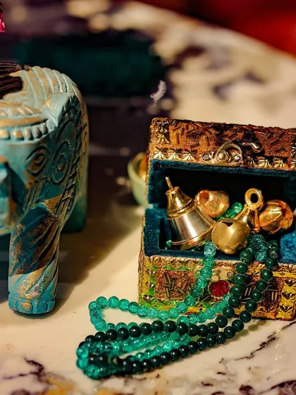 A close-up of decorative elements, including a small carved elephant and a treasure box with beads. These small, thoughtful details add layers of charm and narrative to the overall design.