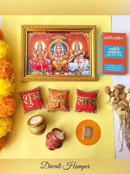 An overhead shot of all the items in our Diwali Hamper, including a Laxmi Ganesh frame, shubh labh pillows, diyas, dry fruits, and more.