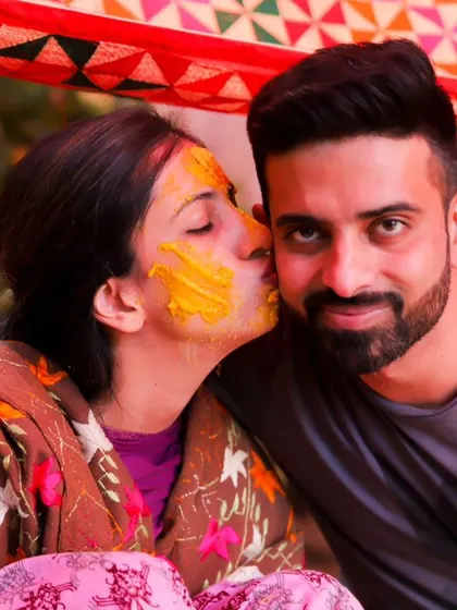 A playful and loving kiss on the cheek. This candid Haldi photo is full of affection and captures the fun, intimate bond between the couple.