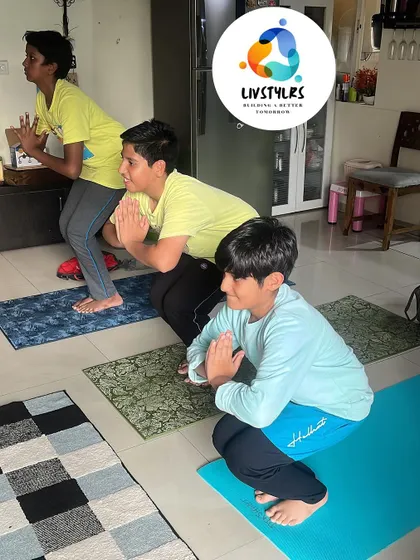 A group of boys hold a deep squat (Malasana), a foundational pose for building lower body strength and hip mobility.