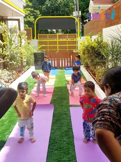 Toddlers participate in a yoga session with their teachers. We adapt poses to make them safe and fun for our youngest students.