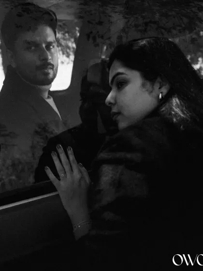 A creative double-exposure effect in black and white, blending the couple's portraits with a car window for an artistic pre-wedding shot.