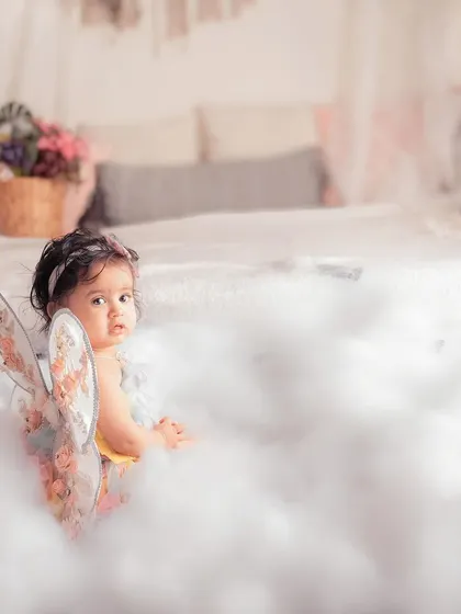 This little fairy with the most gorgeous eyes is peeking out from a sea of clouds. The soft lighting and dreamy setup make this a truly magical portrait.