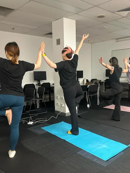 A view from the back of the class, showing everyone's unique expression of the tree pose. There is no perfect pose, only your personal journey.