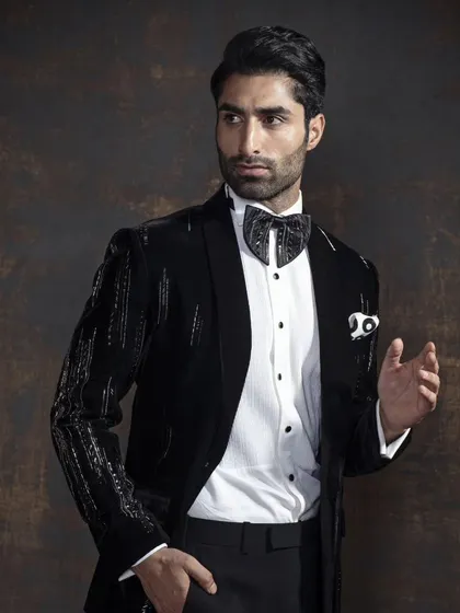 A closer look at the sequined tuxedo, showing the intricate detail and the way it catches the light. It’s paired with a patterned bow tie for an extra layer of personality.