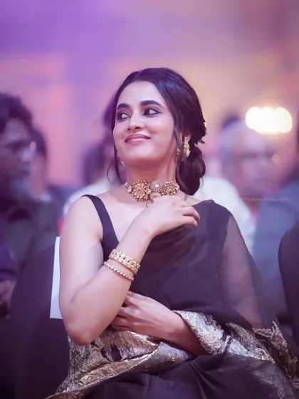 A candid photograph of actress Priyanka Mohan seated in the audience at an event. I focus on capturing natural, unposed moments that show a different side of public figures.