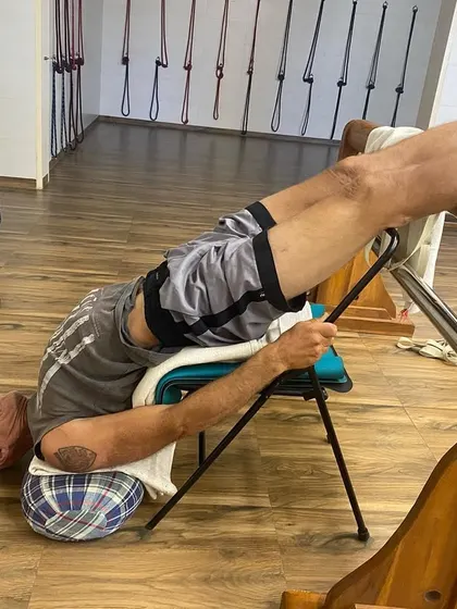 A visiting yoga practitioner from the Czech Republic experiencing a supported backbend on a chair and yoga bench. This setup helps to open the thoracic spine and is excellent for improving posture.