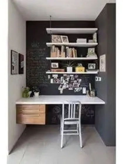 This study nook makes great use of a small alcove. It features a floating desk with a drawer and simple wall shelves against a dark accent wall.