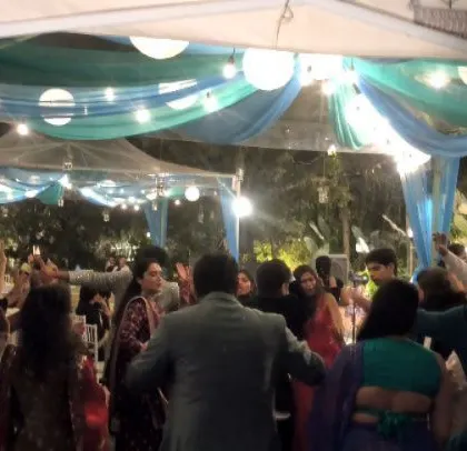 Guests with their hands up, dancing to the Punjabi beats.