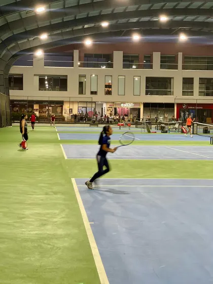 A player mid-rally during a UTR tournament held at our academy. The blurred motion captures the speed and intensity of competitive play.