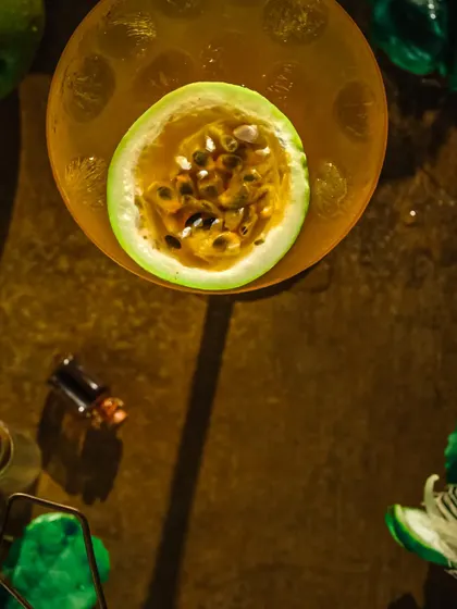 An artistic, high-contrast shot of the passion fruit garnish, using shadows to create a dramatic effect.