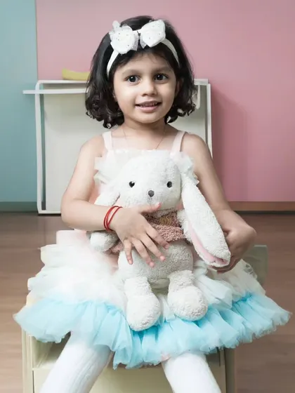 A little girl in a beautiful tutu dress, holding her stuffed bunny close. A sweet and classic portrait that captures her gentle nature.