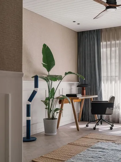A view into the den, showing the comfortable work-from-home setup. The space is designed to be flexible, adapting to the family's needs while maintaining a calm and organized feel.