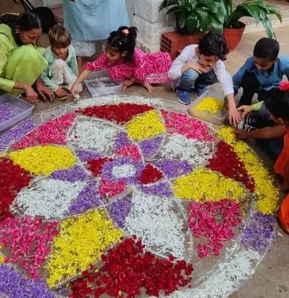 Children of all ages work together to create a beautiful pookolam (flower rangoli) for our Diwali celebration. This collaborative art project fills our space with color, fragrance, and festive spirit.